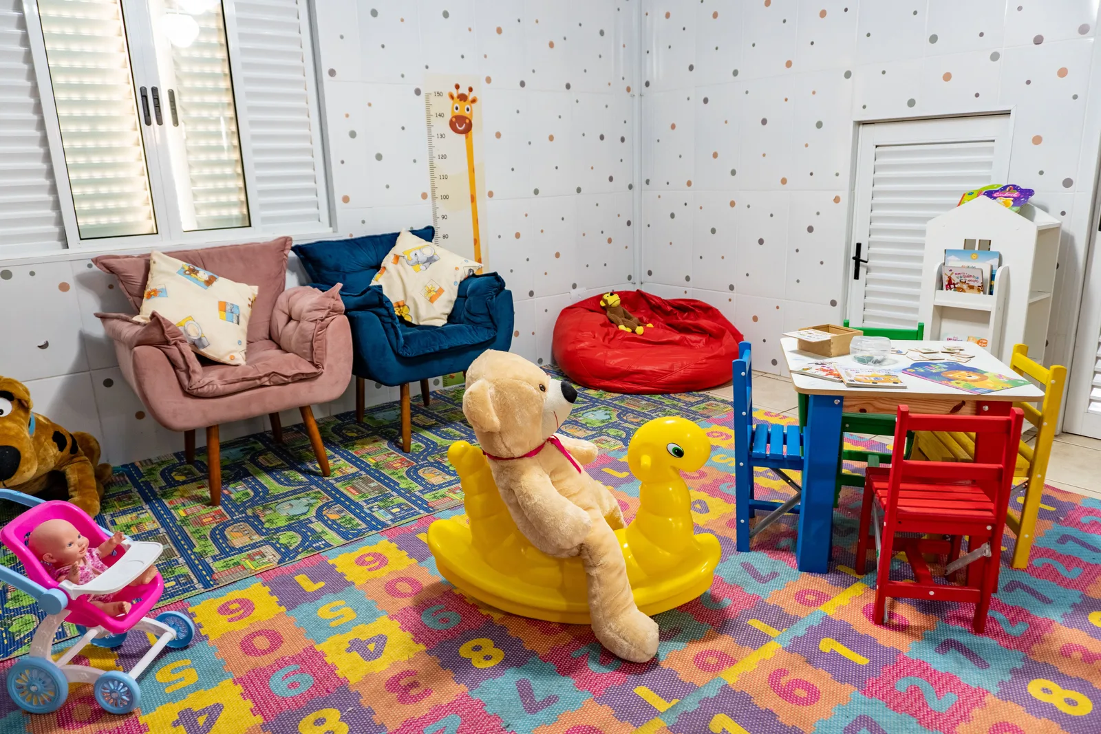 Área de descanso do Espaço Kids da Pousada Cataratas, com poltronas, tapete e brinquedos