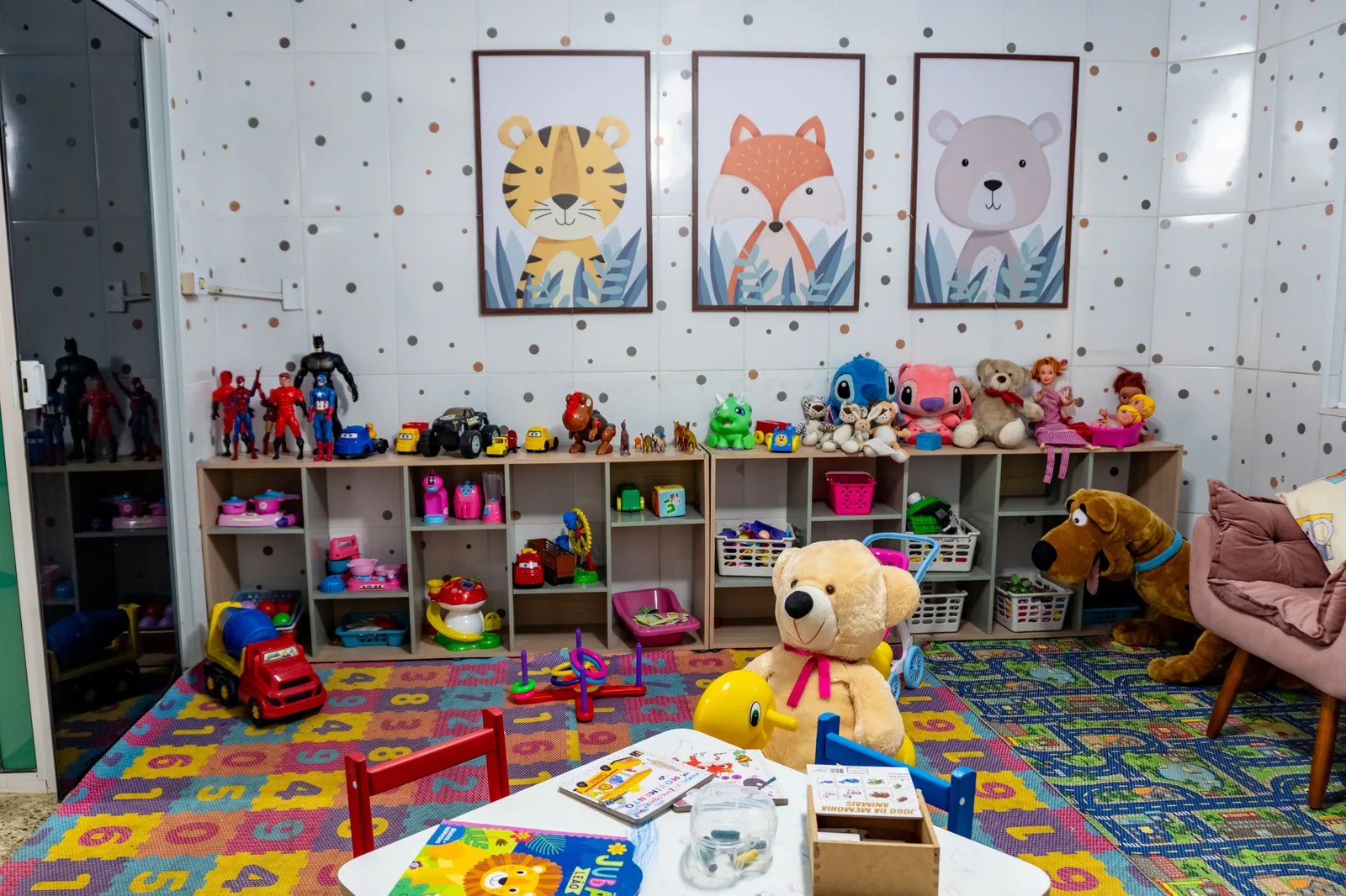 Mesa de atividades e prateleiras de brinquedos do Espaço Kids da Pousada Cataratas em Foz do Iguaçu